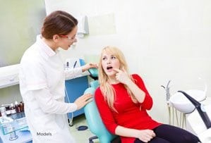 Blonde Patient in Examination Chair showing Female Dentist Source of Pain