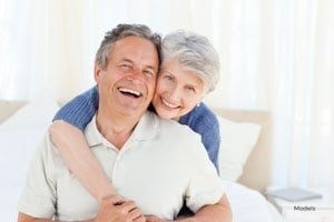 Happy Elderly Couple with Woman Embracing Man from Behind