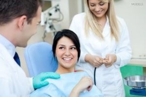 Female Brunette Patient Smiling In Examination Chair