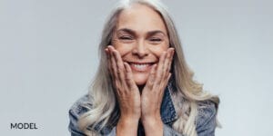 Older Female Patient With Emergency Dental Implants Holding Face with Hands